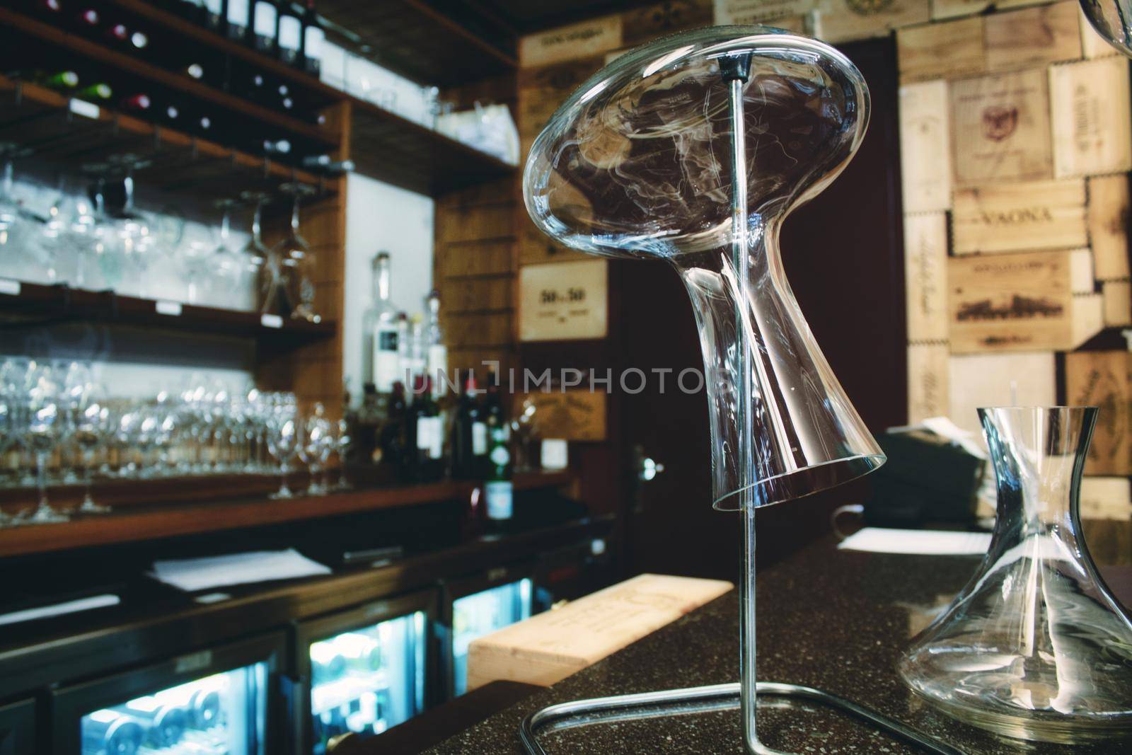 Glass wine decanter on a stand in a trendy wine bar