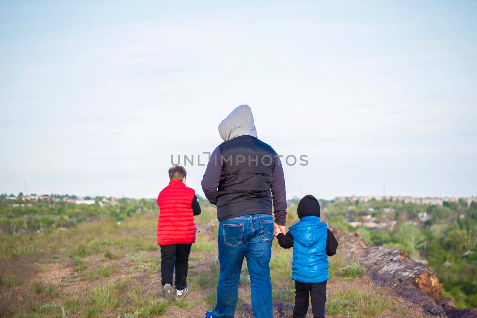 A man and children are standing on a rock and watching what is happening below. panoramic view from above. Russia, Rostov region, skelevataya skala, the 7th wonder of the Don world. Landscape