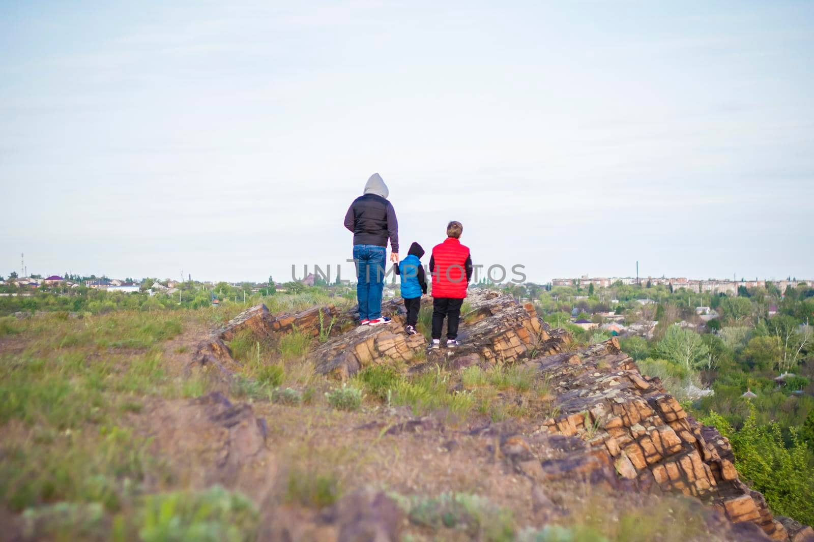 A man and children are standing on a rock and watching what is happening below. panoramic view from above. Russia, Rostov region, skelevataya skala, the 7th wonder of the Don world. Landscape