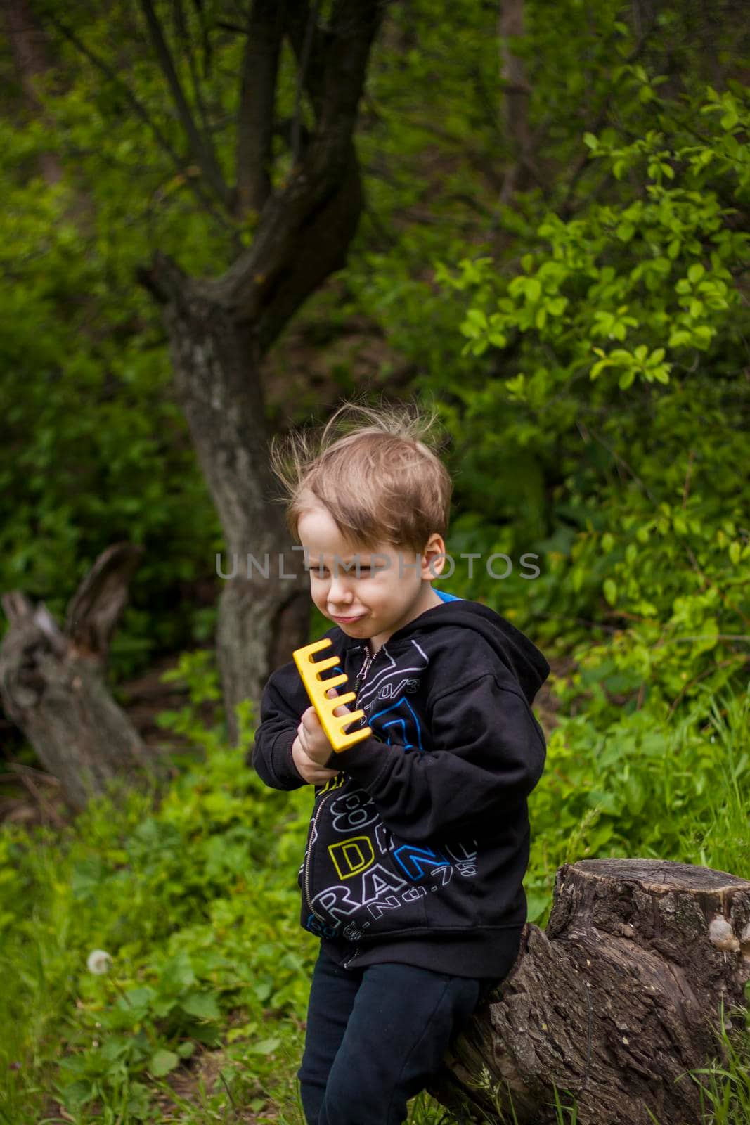 Portrait of a child with a funny facial expression. a walk in the fresh air in the park. Bright and juicy spring greenery around.