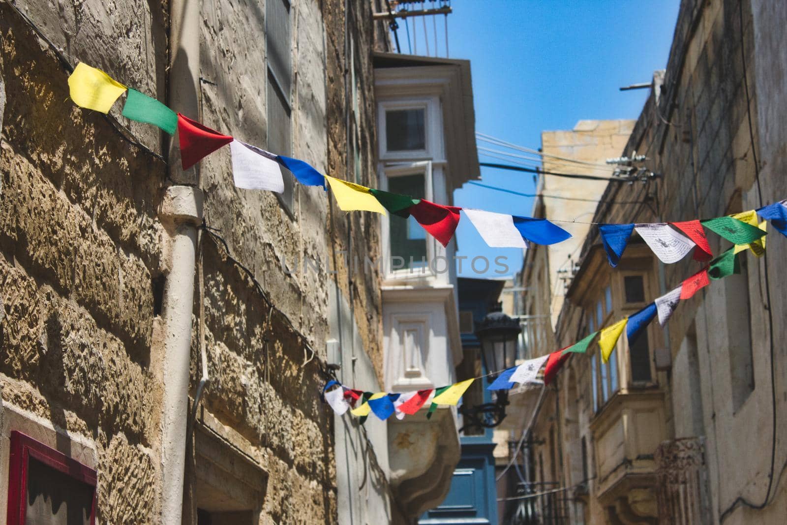 Multi-colored bunting hanging between the houses in a narrow street