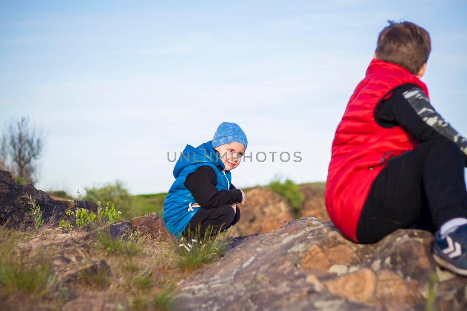 A child sits on top of a cliff and watches what is happening below. panoramic view from the top of a rocky mountain. Russia, Rostov region, skelevataya skala, the 7th wonder of the Don world. Landscape