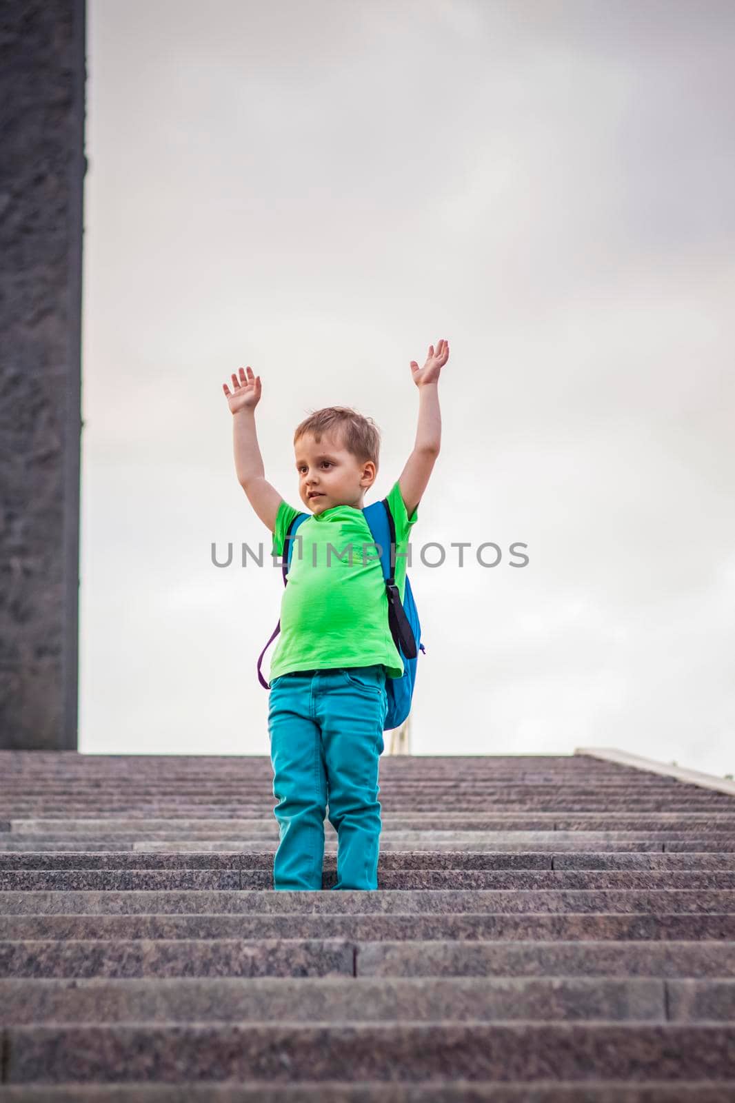 Portrait of a child, a boy against the backdrop of urban landscapes of skyscrapers and high-rise buildings in the open air. Children, Travel. Lifestyle in the city. Center, streets. Summer, a walk.