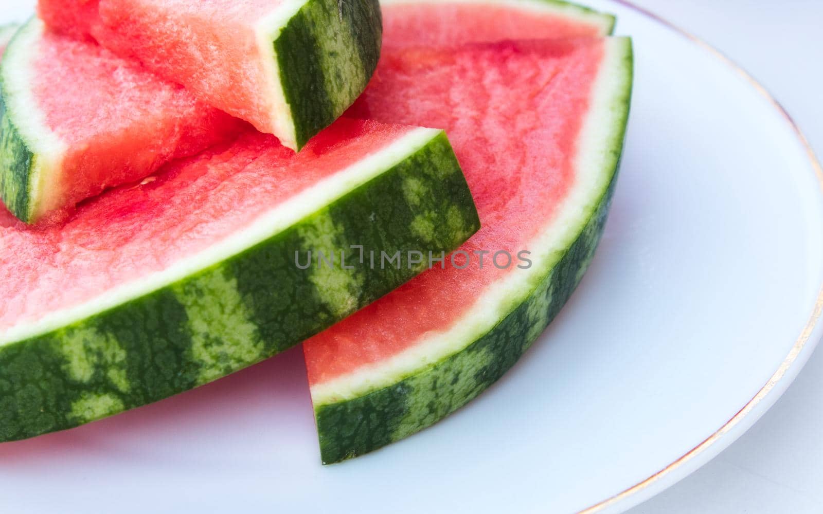 Close up of fresh watermelon slices an a white porcelain plate by tennesseewitney