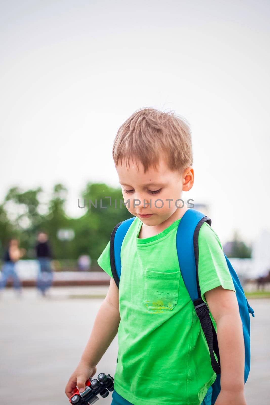 Portrait of a child, a boy against the backdrop of urban landscapes of skyscrapers and high-rise buildings in the open air. Children, Travel. Lifestyle in the city. Center, streets. Summer, a walk.