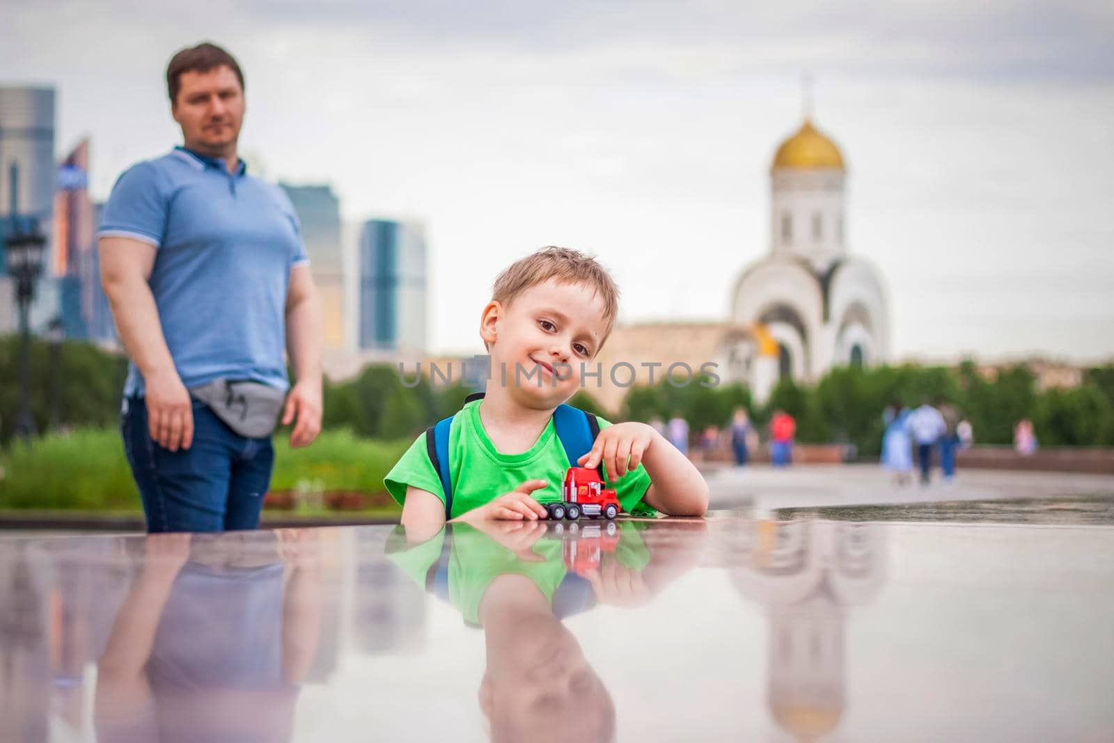 Portrait of a child, a boy against the backdrop of urban landscapes of skyscrapers and high-rise buildings in the open air. Children, Travel. Lifestyle in the city. Center, streets. by Alina_Lebed