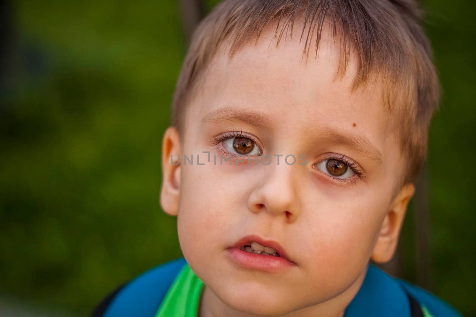 Portrait of a child, a boy against the backdrop of urban landscapes of skyscrapers and high-rise buildings in the open air. Children, Travel. Lifestyle in the city. Center, streets. Summer, a walk.