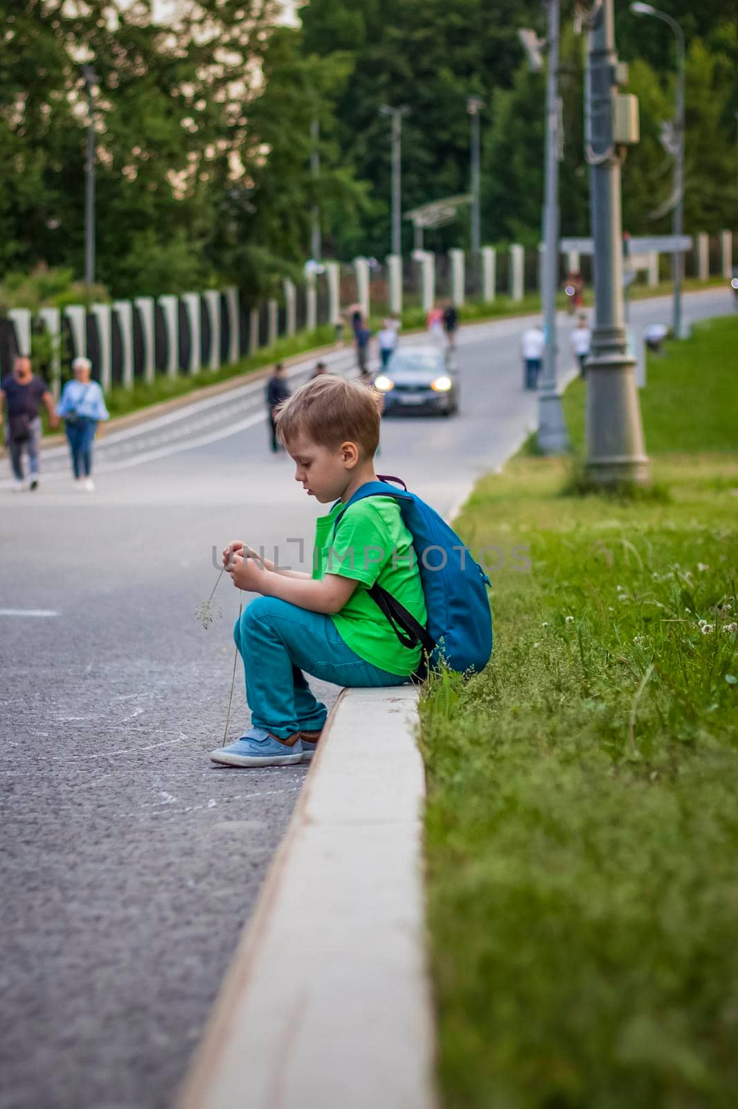 Portrait of a child, a boy against the backdrop of urban landscapes of skyscrapers and high-rise buildings in the open air. Children, Travel. Lifestyle in the city. Center, streets. Summer, a walk.