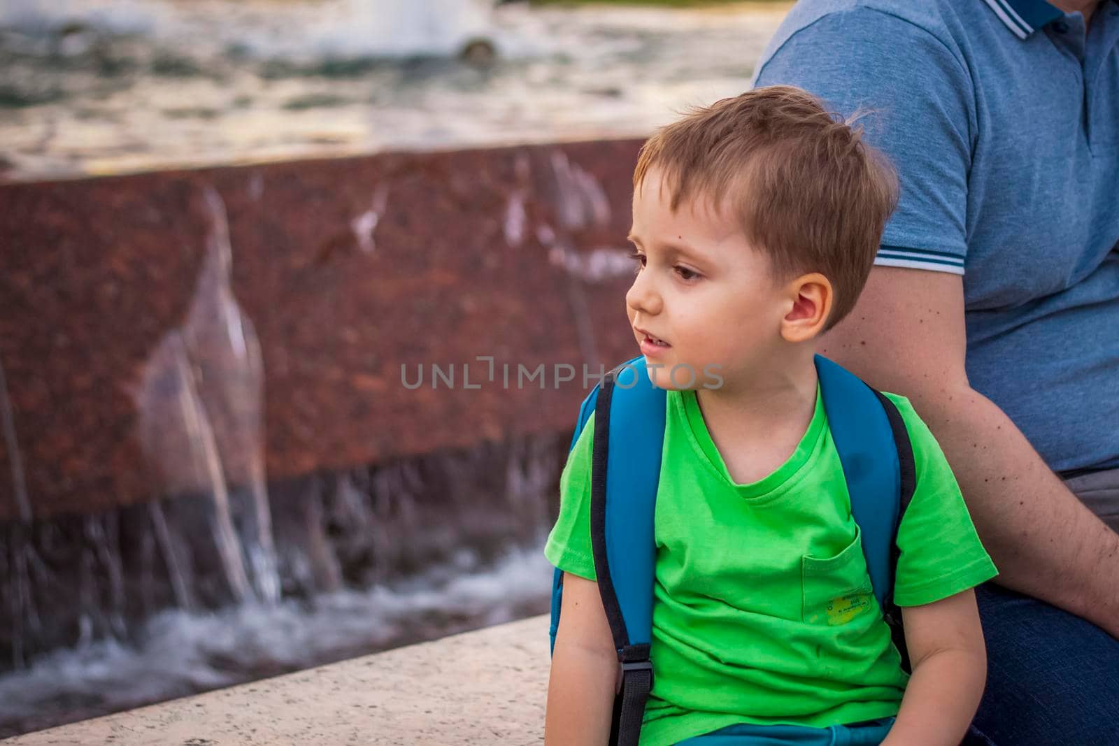 Portrait of a child, a boy against the backdrop of urban landscapes of skyscrapers and high-rise buildings in the open air. Children, Travel. Lifestyle in the city. Center, streets. Summer, a walk.