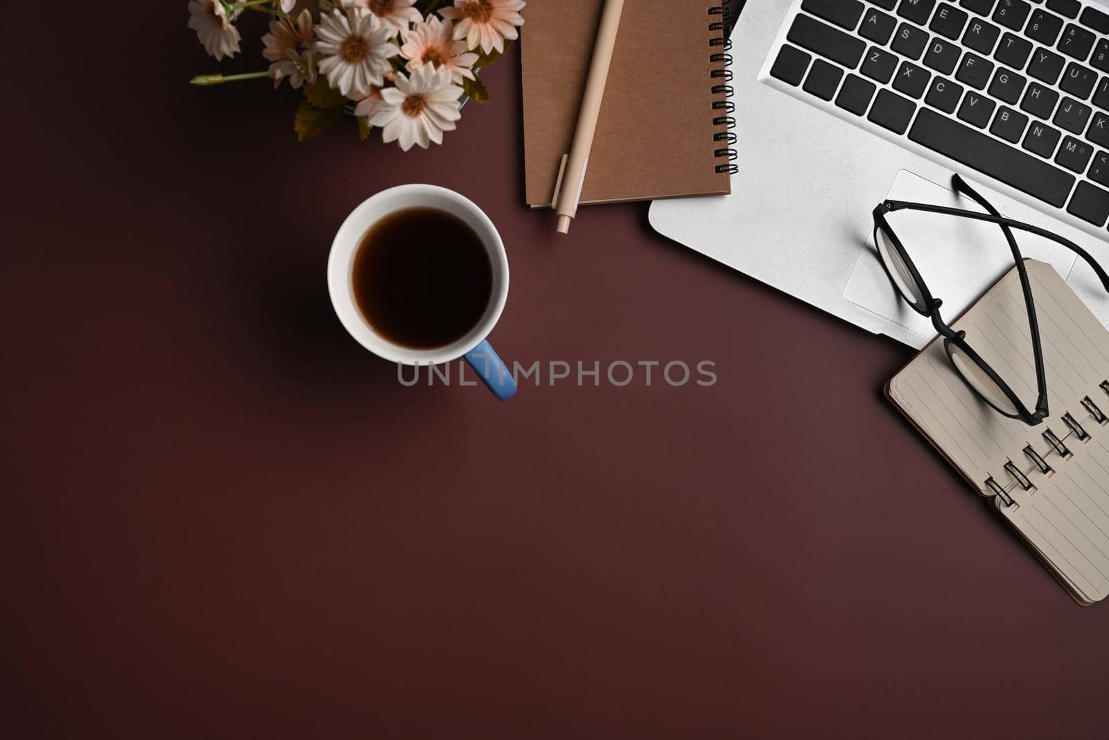 Laptop computer, notebook, glasses and coffee cup on purple background. Flat lay.