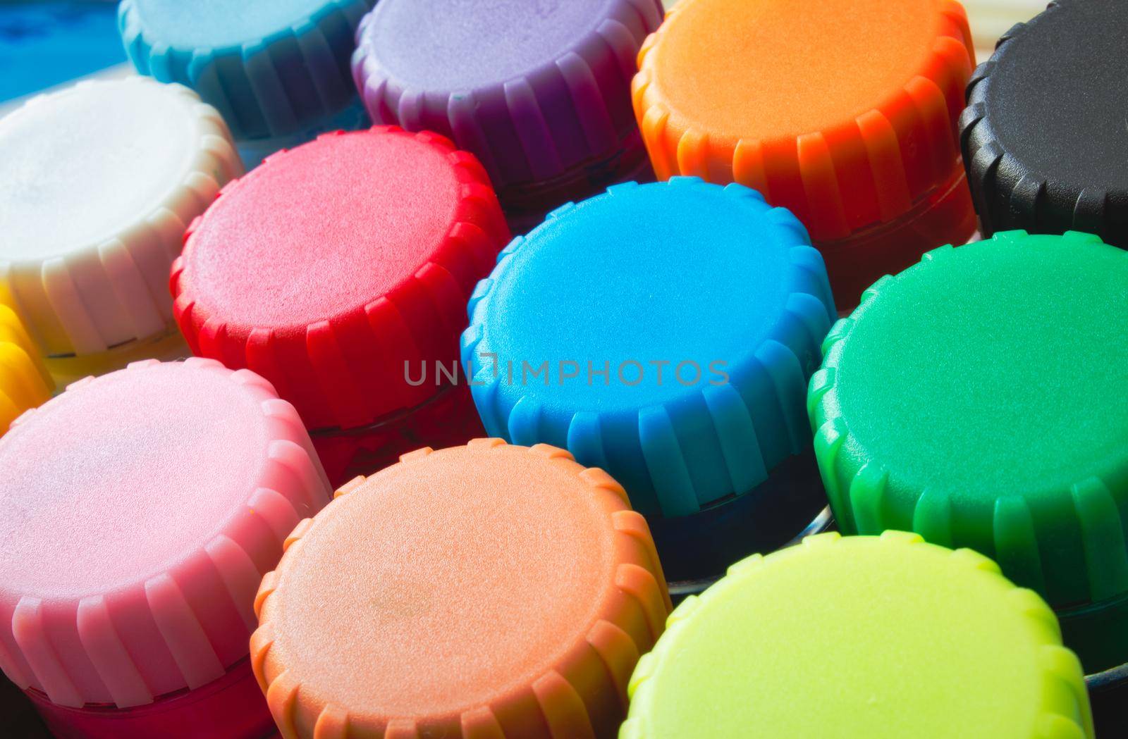 Close-up of colourful lids of kids' poster paint pots by tennesseewitney