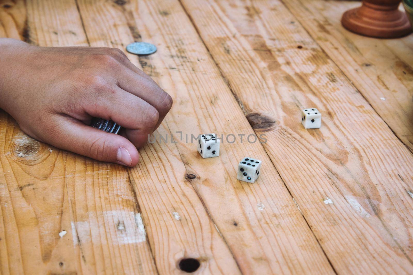 Gambling whilst playing a game with dice on a wooden table by tennesseewitney