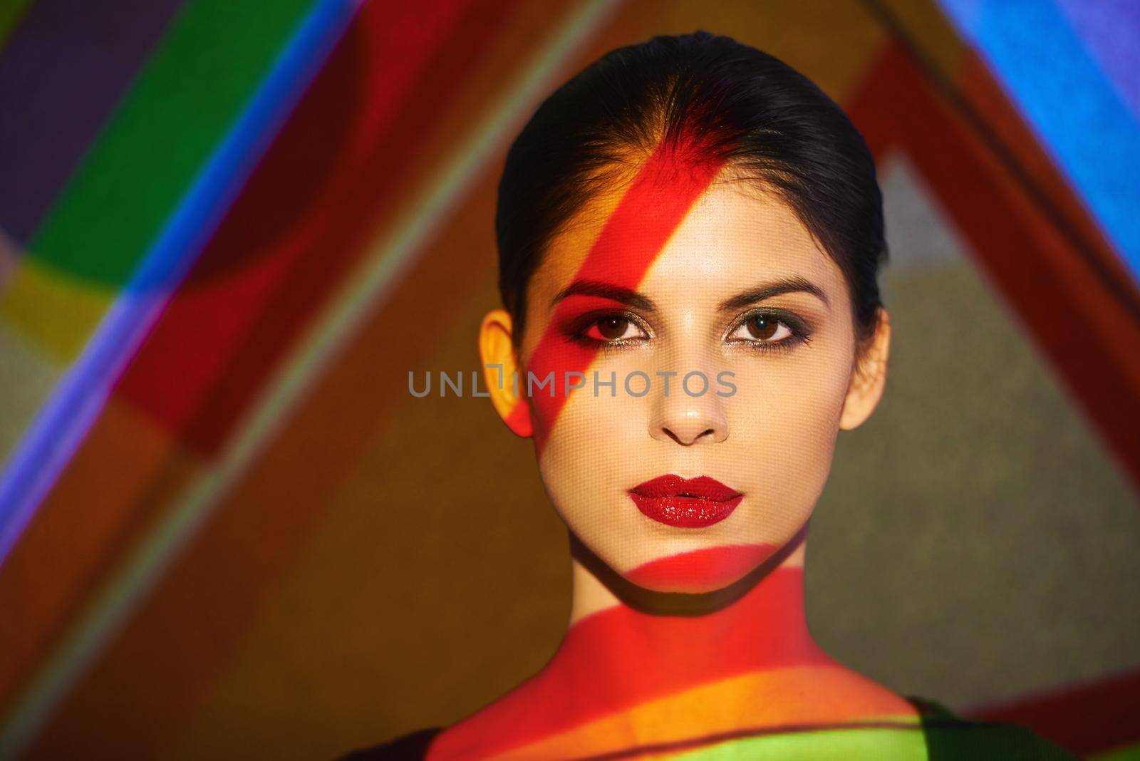 A beautiful model in the studio covered with a myriad of abstract lighting.