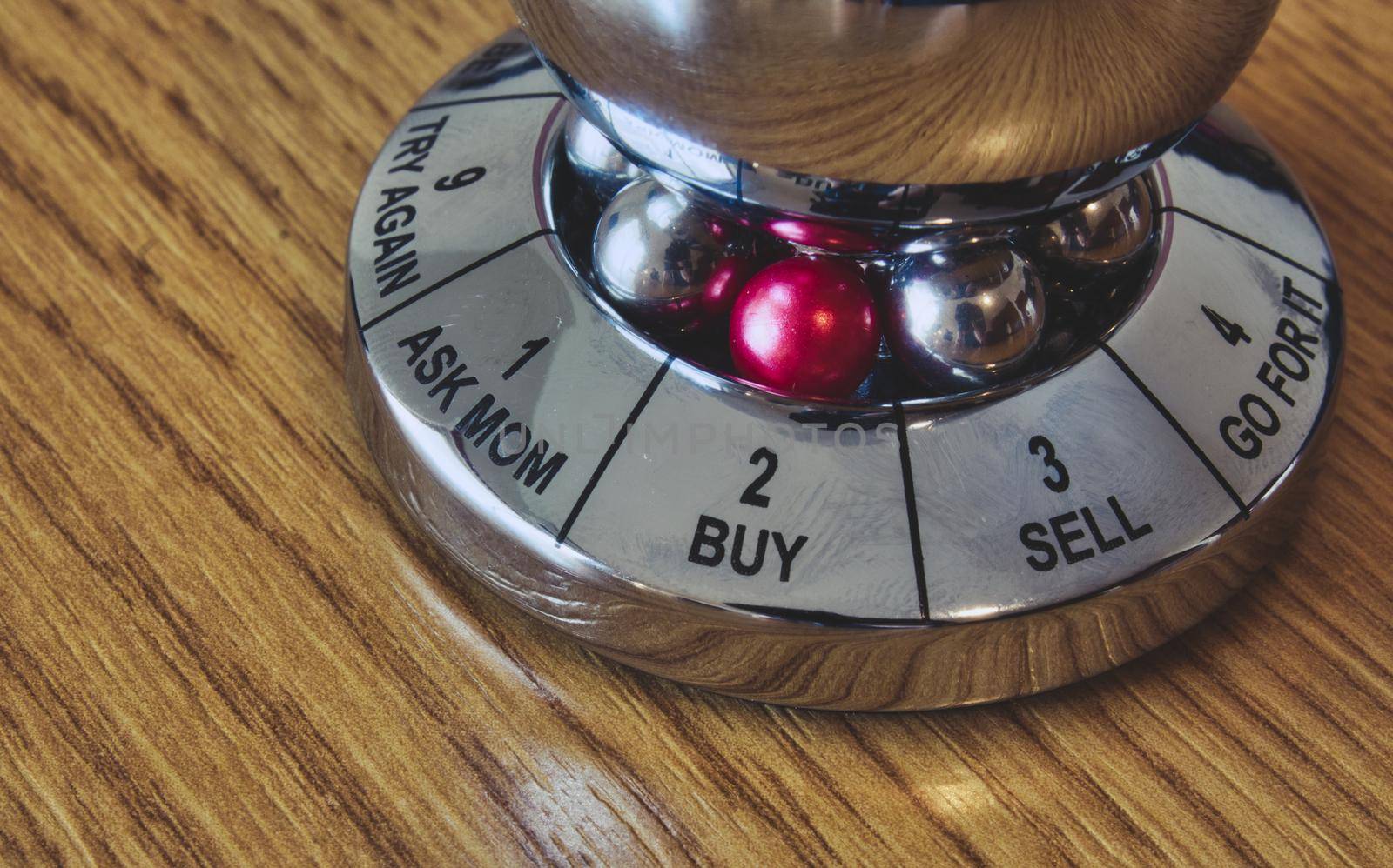 Metal decision maker with 'Buy' selected from the wheel of options