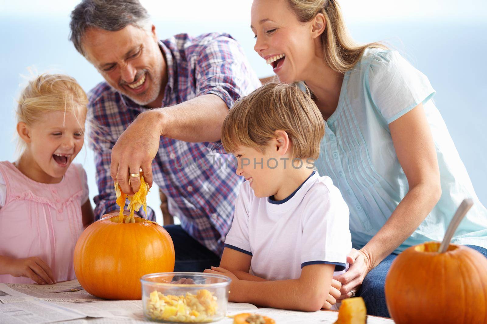 A family of four carving pumpkins at home.