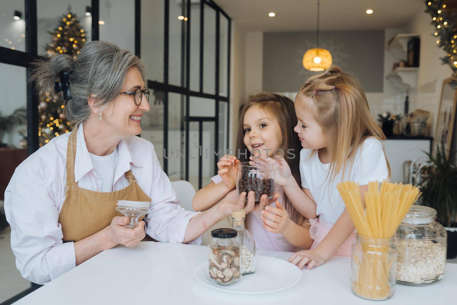 Grandmother and granddaughter are cooking on kitchen. Grandmother shares experience