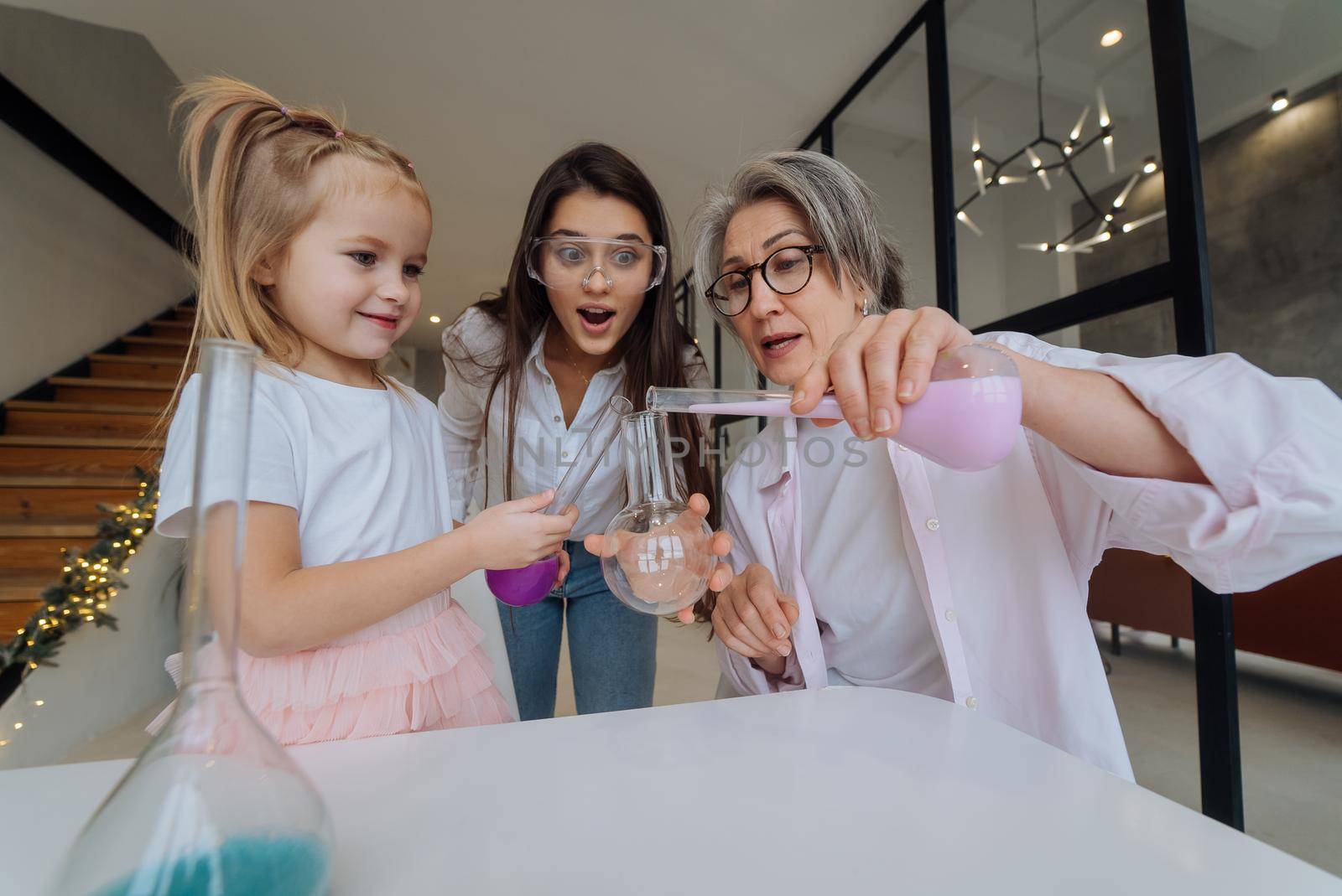 Family doing chemical experiment, mixing flasks indoors by teksomolika