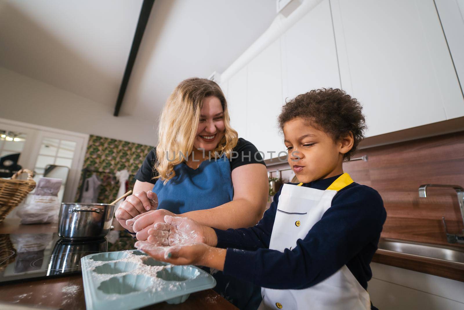 Happy family having fun in the kitchen. Mom teaches her little daughter to cook.