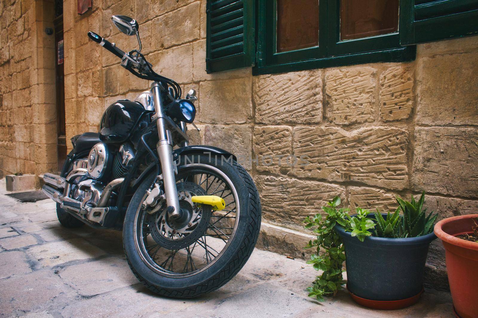 Motorbike parked in front of a Mediterranean rural village house
