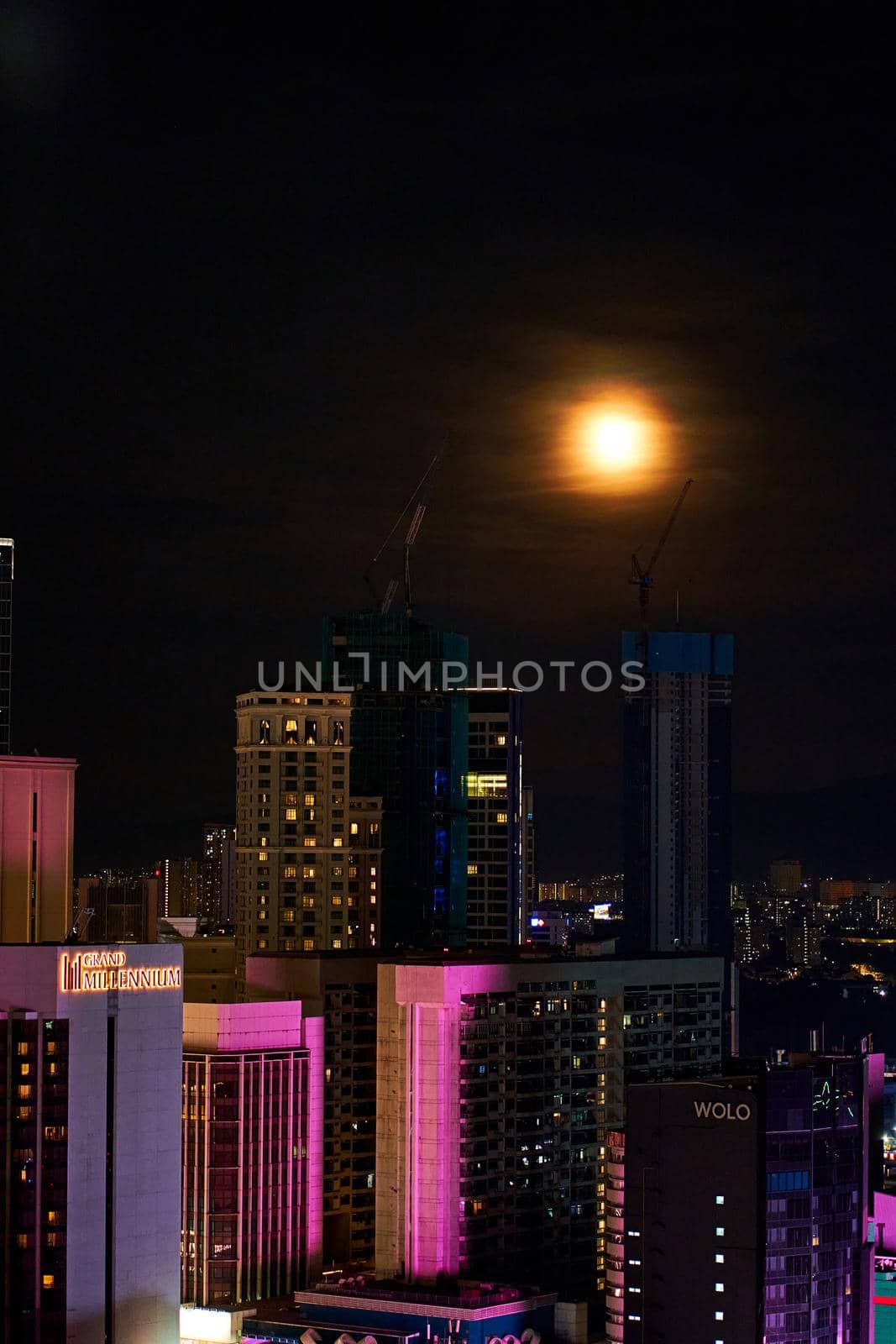 Bright full moon in the night sky over the metropolis.