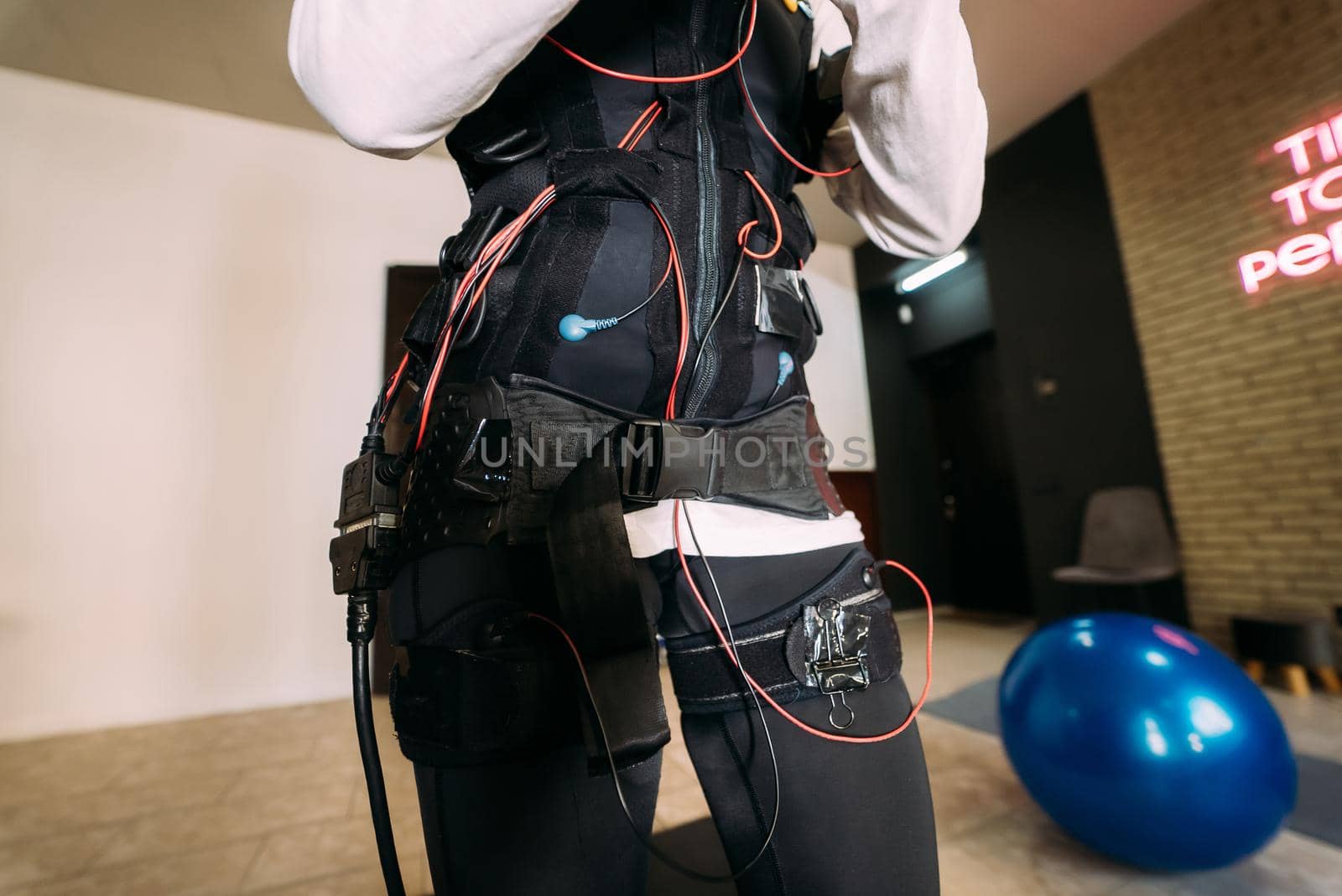 Girl doing exercises in a suit with cables.