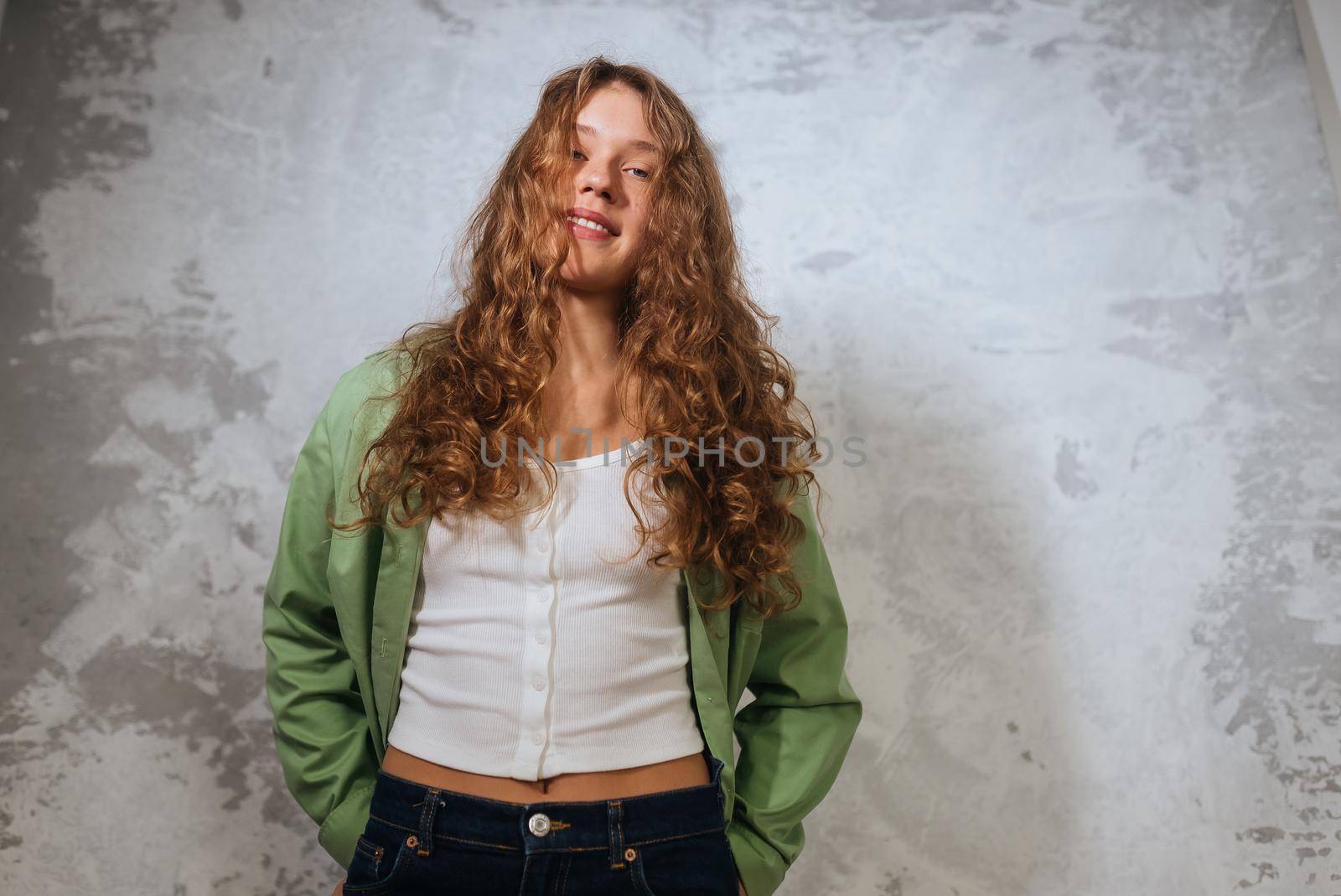 Pretty female looking at camera. Studio shot of good-looking beautiful woman isolated against blank studio wall.
