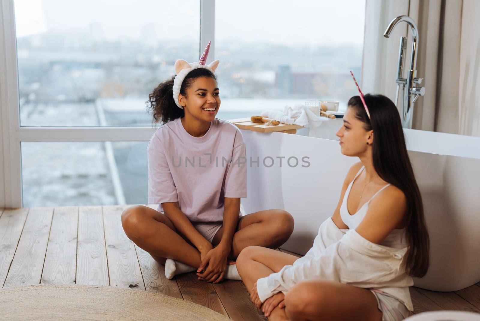 Two girls talking on the bathroom floor