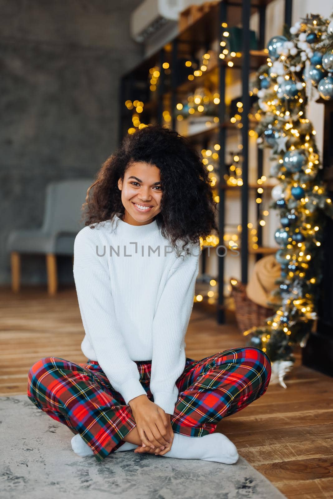 Beautiful young african american woman on the floor happy face smiling and looking at the camera. Positive person.