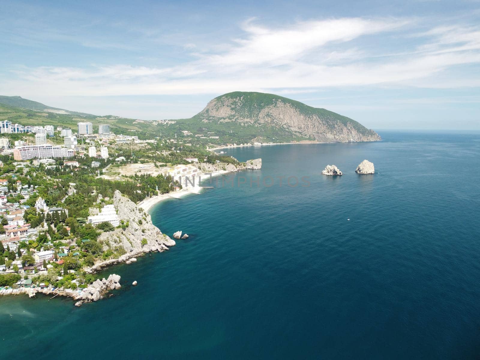 Aerial panoramic view on Gurzuf resort city and Bear Mountain, Ayu-Dag, Yalta, Crimea. Spring sunny day. Nature summer ocean sea beach background. Vacation, travel and holiday concept. by panophotograph