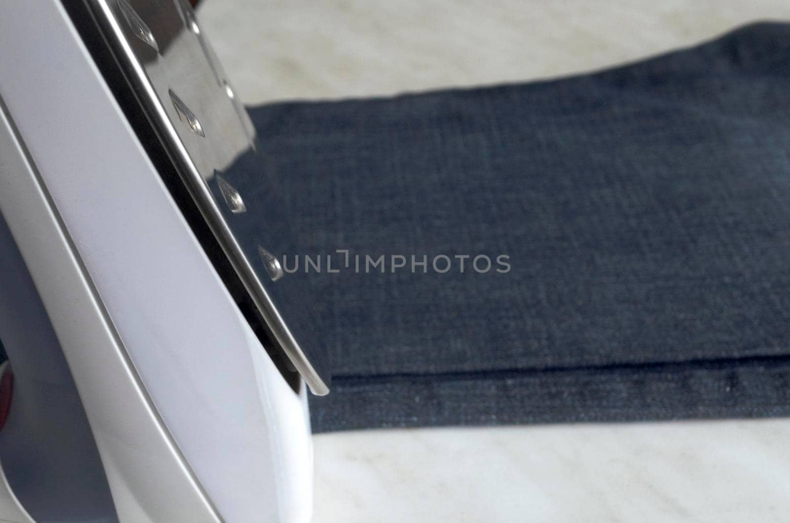 steam iron with metal sole on the background of jeans for ironing, copyspace