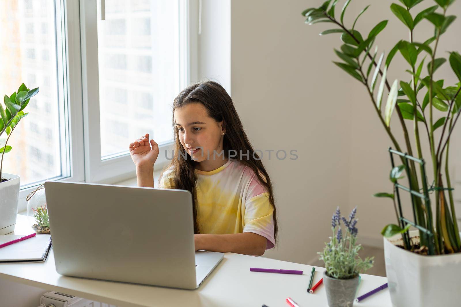 Excited Teen Girl Sitting In Living Room With Laptop, During Webinar At Home. Online School Tests Concept by Andelov13