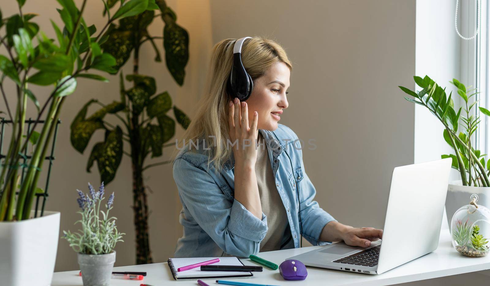 Young teacher tutor student on online remote lesson using laptop, listening to the schoolchildren students, writing checking homework at school classroom