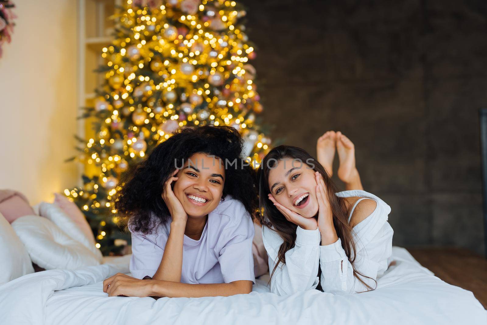 Two girlfriends gossip on the bed