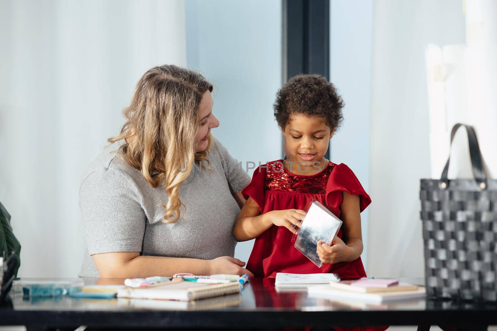 Mother and child daughter draws creatively at home at the table