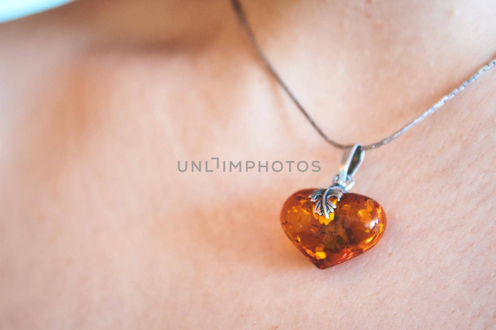 A heart shaped amber pendant worn around the neck of a young woman by tennesseewitney