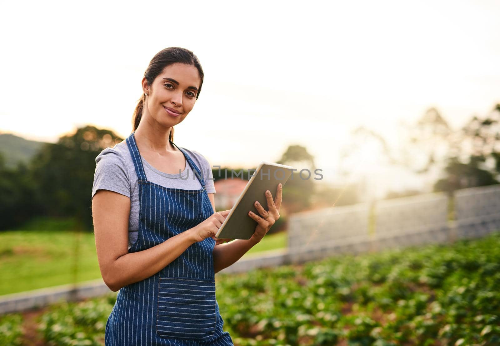 Portrait of an attractive young woman using a tablet while working on her farm.
