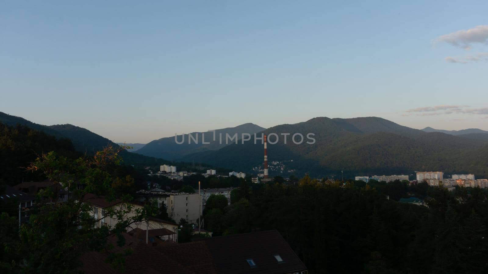 LAZAREVSKOE, SOCHI, RUSSIA - MAY, 27, 2021: Panorama of sunset in the mountains. A magical view of the sea and small town from the observation deck.