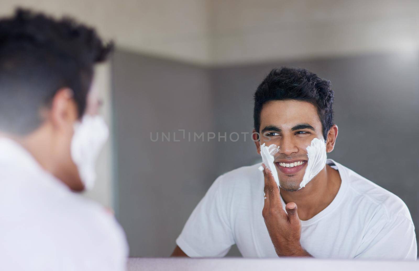 Sprucing up before a big date. Shot of a handsome young man shaving his facial hair in the bathroom. by YuriArcurs