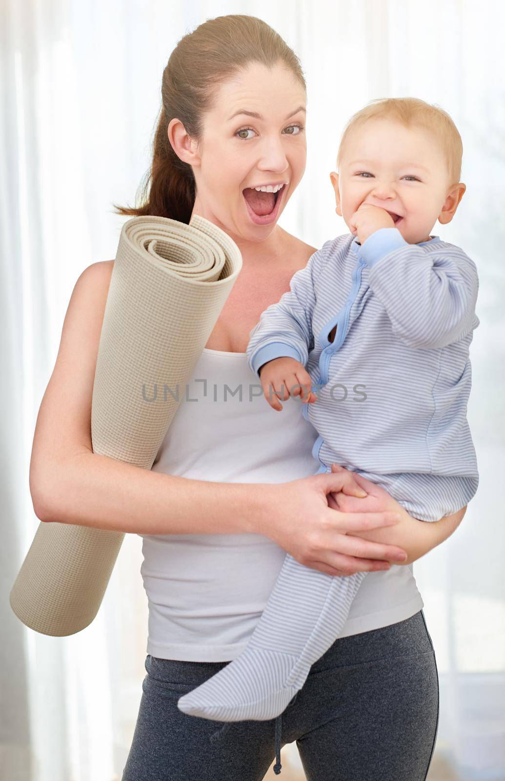 Shot of a young woman working out while spending time with her baby boy.