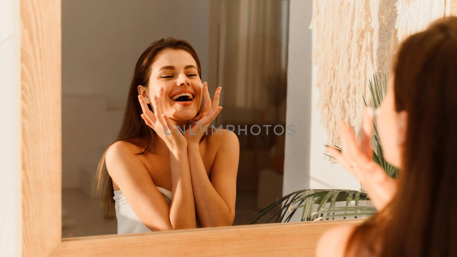 Happy woman doing daily routine moisturizing skin in the morning. Web banner.