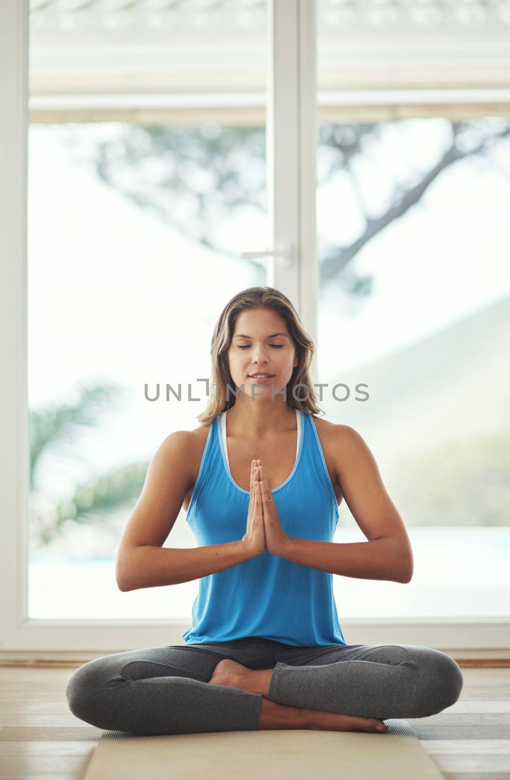 Full length shot of a young woman practicing the art of meditation at home.