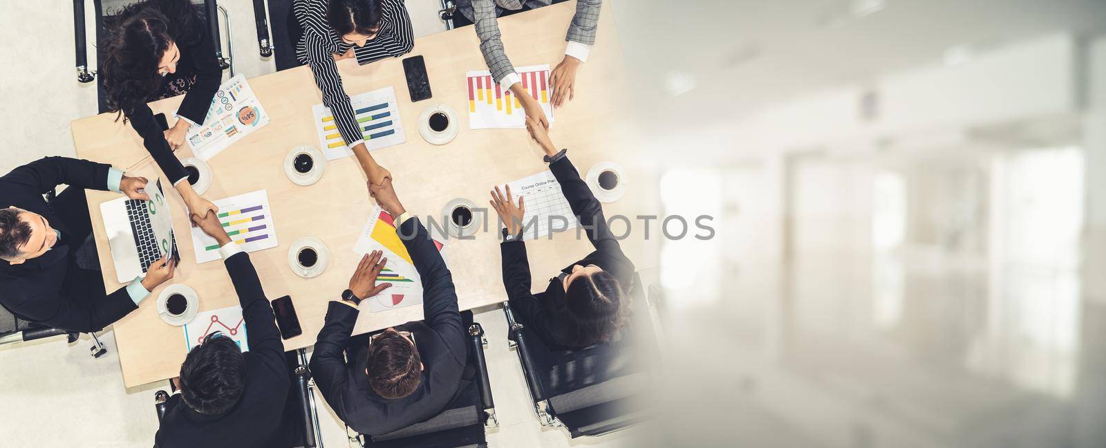 Group business people handshake at meeting table in office together with confident shot from top view . Young businessman and businesswoman workers express agreement of investment deal. broaden view