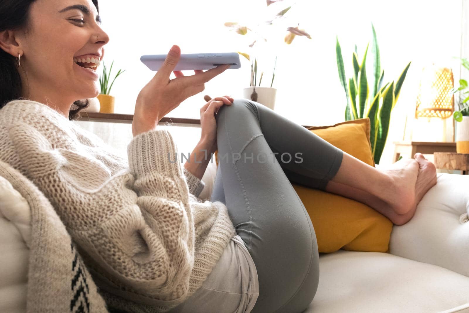 Young happy caucasian woman using smartphone to send voice message. Technology concept.