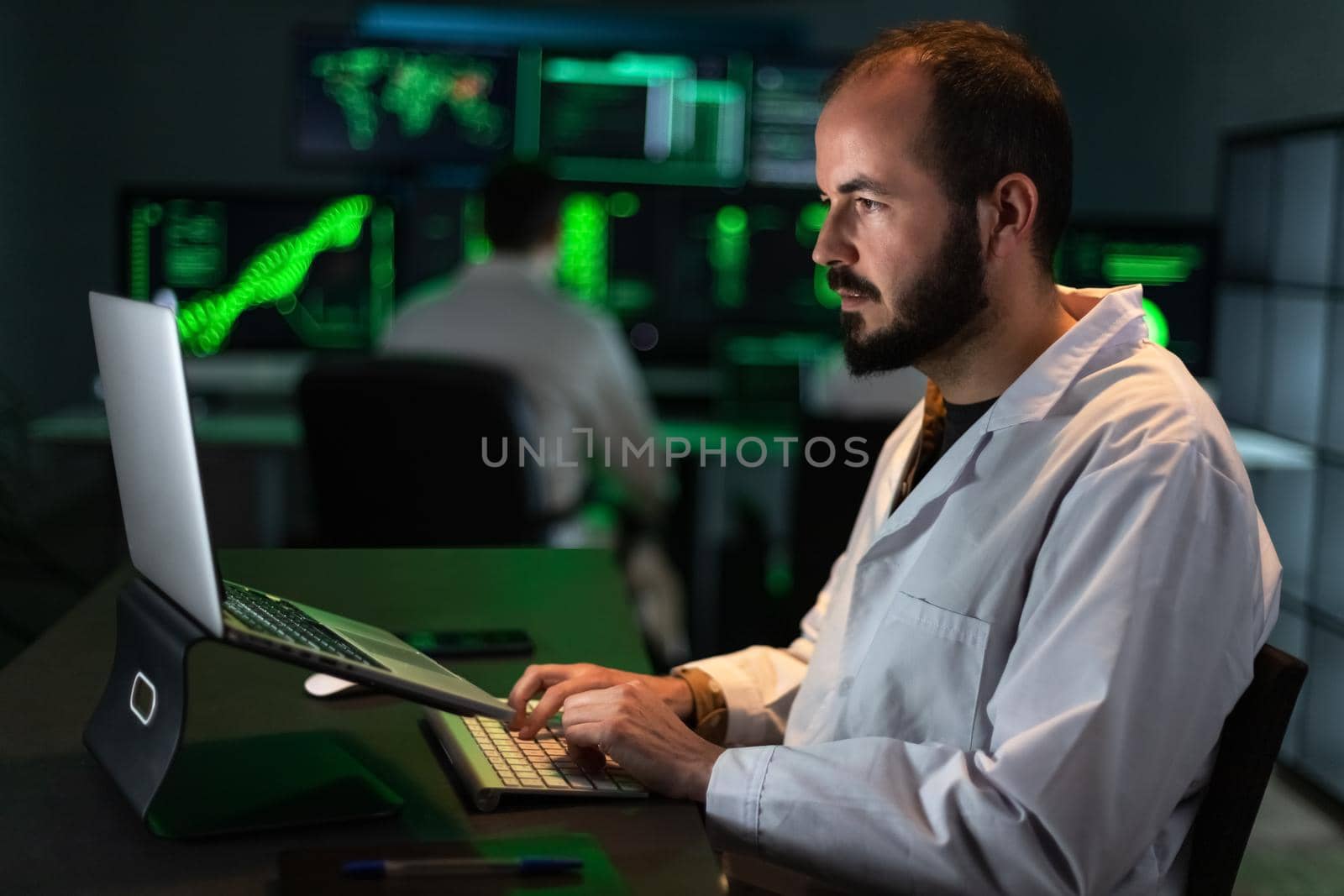 Caucasian male scientist working in the office lab using his laptop. Science and technology concept.