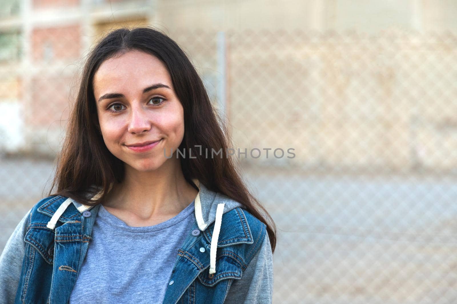 Happy caucasian girl with long hair looking at camera outside. Copy space. Headshot.