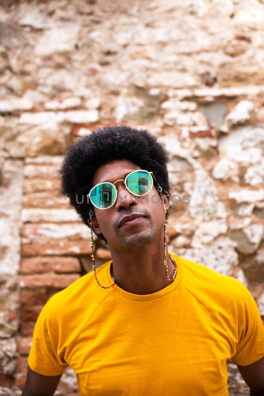 Vertical portrait of cool and confident black man wearing sunglasses outdoors. Copy space. Lifestyle concept.