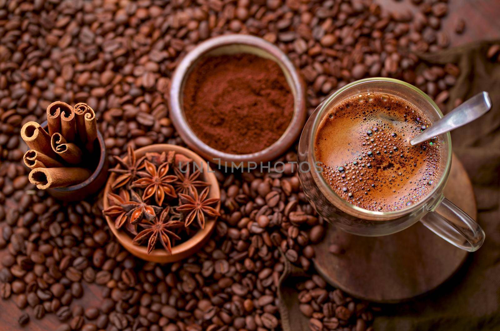 Tasty steaming espresso in cup with coffee beans. View from above. Dark background.