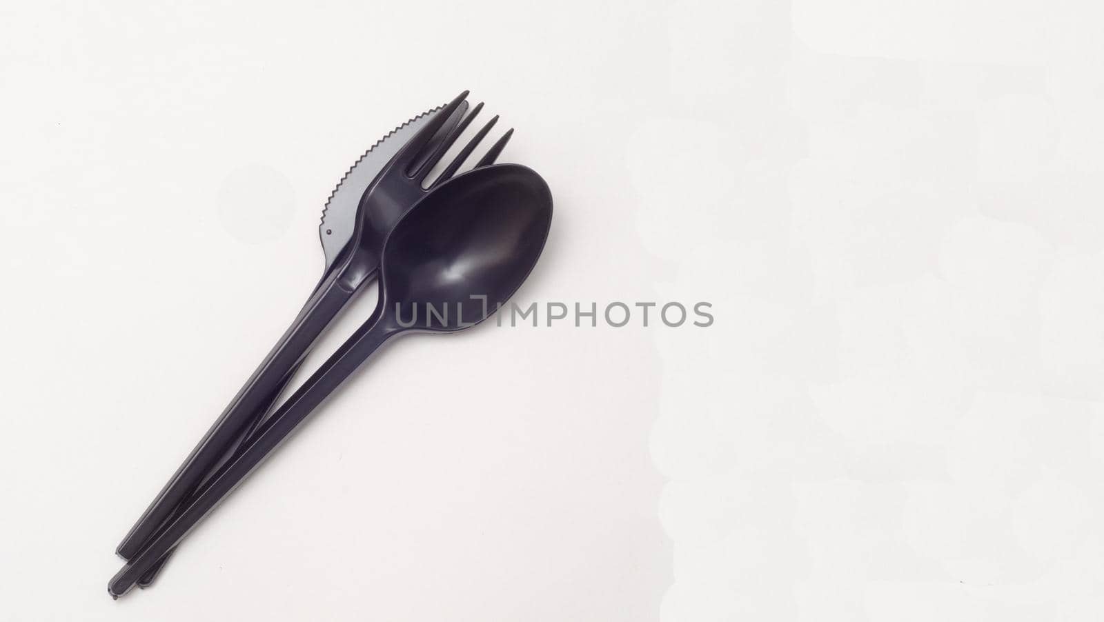 black plastic disposable knife,spoon on white background, copyspace
