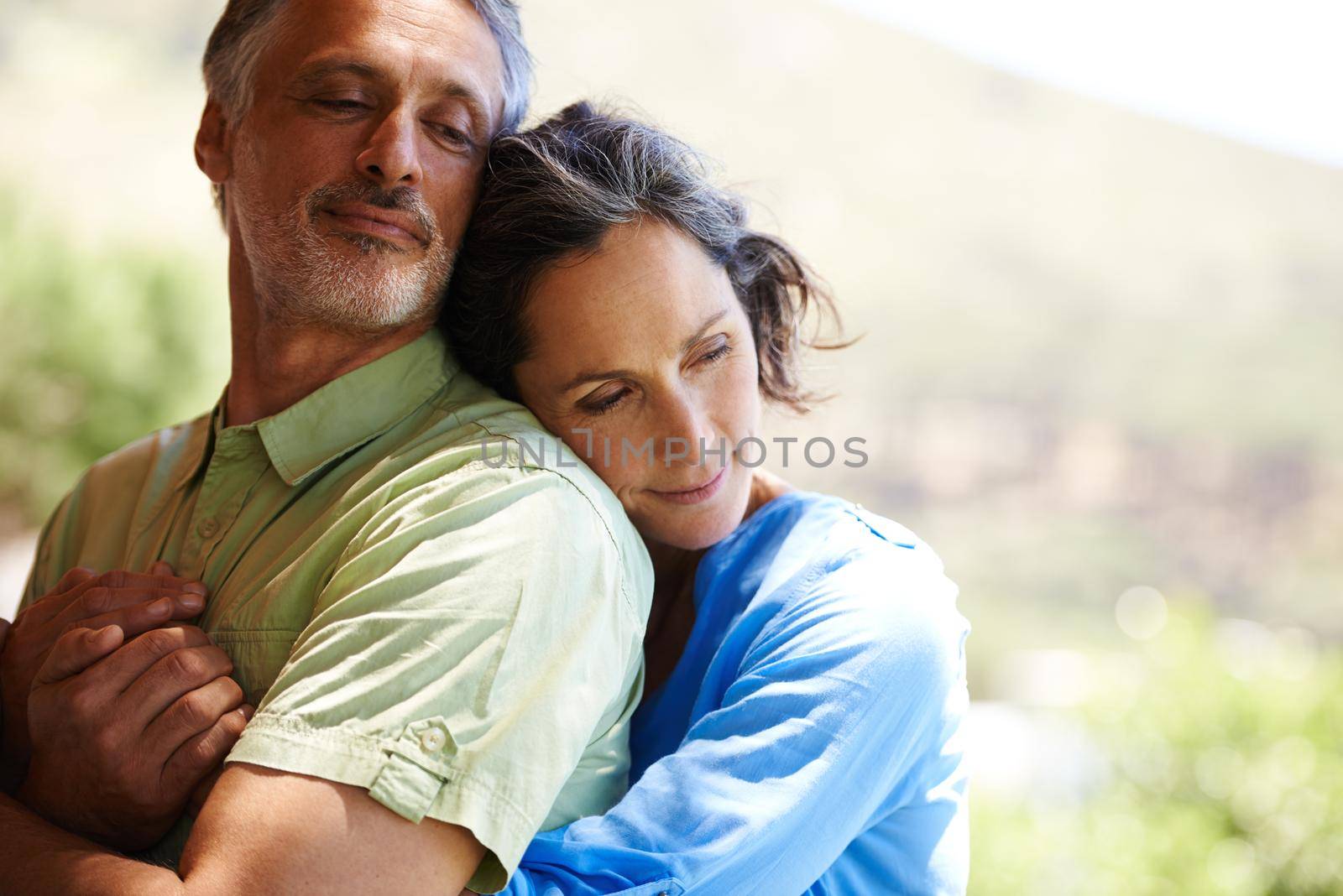 Youre all I need. A cropped shot of an affectionate mid adult couple holding each other outdoors. by YuriArcurs