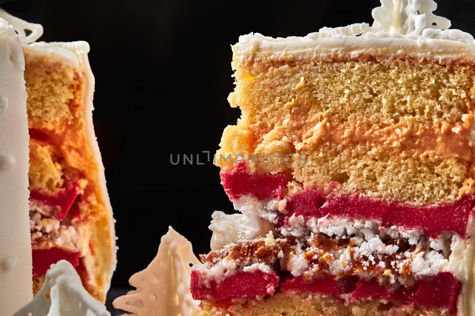 Macro shot of a pink cream cutaway cake against a black studio background. Pastries, delicious holiday bake.